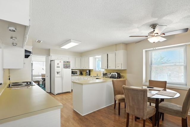 2910 Riata Ln, Houston, TX 77043 - kitchen featuring white appliances, a peninsula, light wood finished floors, light countertops, and ceiling fan