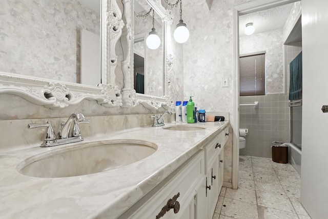 2910 Riata Ln, Houston, TX 77043 - full bath with double vanity, tile walls, tile patterned flooring, and combined bath / shower with glass door