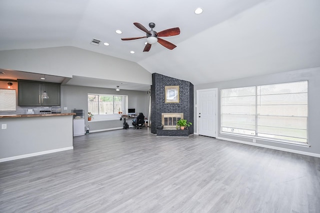19923 Ricewood Way, Katy, TX 77449 - unfurnished living room featuring lofted ceiling, ceiling fan, wood finished floors, and a brick fireplace