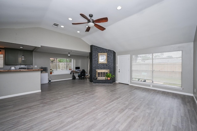 19923 Ricewood Way, Katy, TX 77449 - unfurnished living room with lofted ceiling, a ceiling fan, a fireplace, and wood finished floors