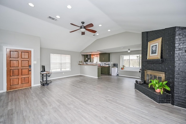19923 Ricewood Way, Katy, TX 77449 - unfurnished living room featuring a ceiling fan, vaulted ceiling, a brick fireplace, wood finished floors, and recessed lighting