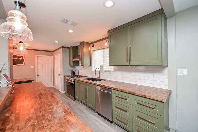 19923 Ricewood Way, Katy, TX 77449 - kitchen featuring butcher block countertops, stainless steel appliances, green cabinetry, backsplash, and recessed lighting