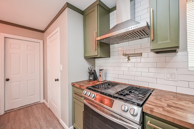 19923 Ricewood Way, Katy, TX 77449 - kitchen featuring green cabinetry, stainless steel range with gas stovetop, wall chimney range hood, wood counters, and tasteful backsplash