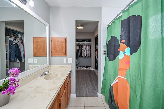 19923 Ricewood Way, Katy, TX 77449 - bathroom with a walk in closet, vanity, and tile patterned flooring