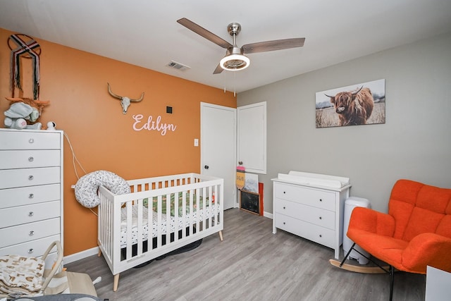 19923 Ricewood Way, Katy, TX 77449 - bedroom featuring wood finished floors, a nursery area, and ceiling fan