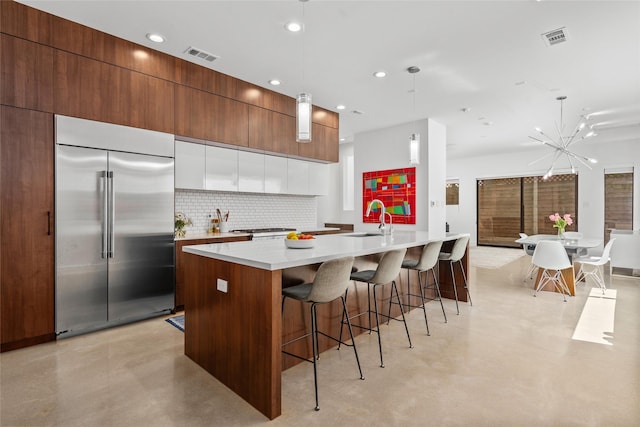 509 W Drew St, Houston, TX 77006 - kitchen with stainless steel built in fridge, modern cabinets, decorative backsplash, a kitchen breakfast bar, and light countertops