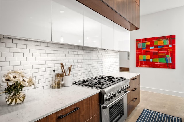 509 W Drew St, Houston, TX 77006 - kitchen featuring high end range, modern cabinets, white cabinetry, tasteful backsplash, and concrete floors