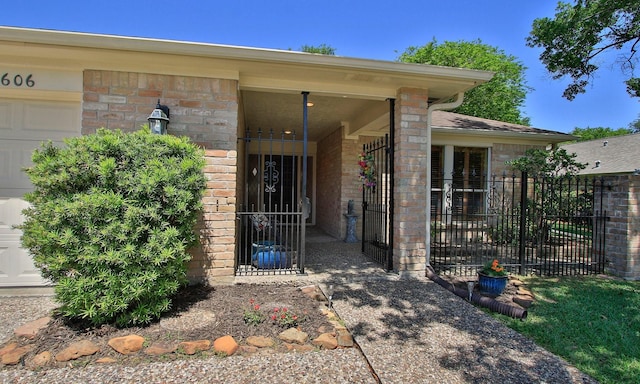 6606 Preston Trail Dr, Houston, TX 77069 - view of exterior entry with an attached garage, a gate, and brick siding