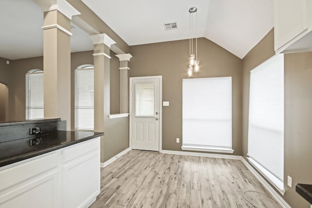 15919 Shadow Pass Trl, Tomball, TX 77377 - kitchen featuring dark countertops, light wood-type flooring, white cabinetry, ornate columns, and lofted ceiling