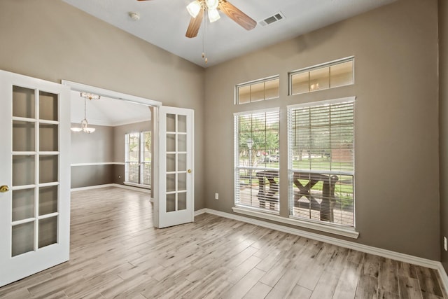 15919 Shadow Pass Trl, Tomball, TX 77377 - spare room with french doors, a chandelier, wood finished floors, and a ceiling fan