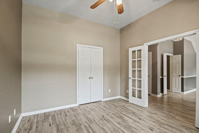 15919 Shadow Pass Trl, Tomball, TX 77377 - unfurnished bedroom featuring wood finished floors, french doors, a ceiling fan, a chandelier, and a closet