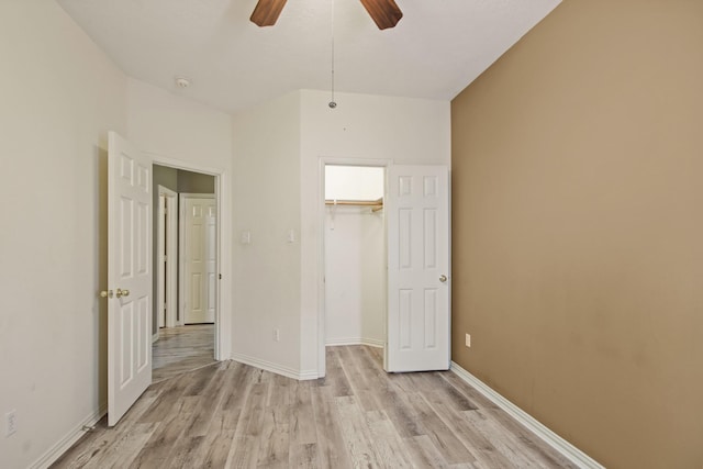 15919 Shadow Pass Trl, Tomball, TX 77377 - unfurnished bedroom featuring light wood-style flooring, a walk in closet, and a ceiling fan