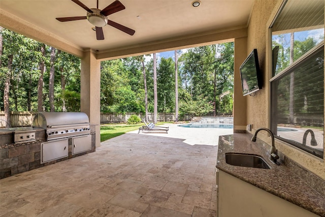 193 Grogans Point Rd, The Woodlands, TX 77380 - fenced backyard featuring an outdoor kitchen, a patio area, a ceiling fan, and view of scattered trees