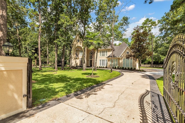 193 Grogans Point Rd, The Woodlands, TX 77380 - view of front of house featuring a front yard, concrete driveway, and stucco siding