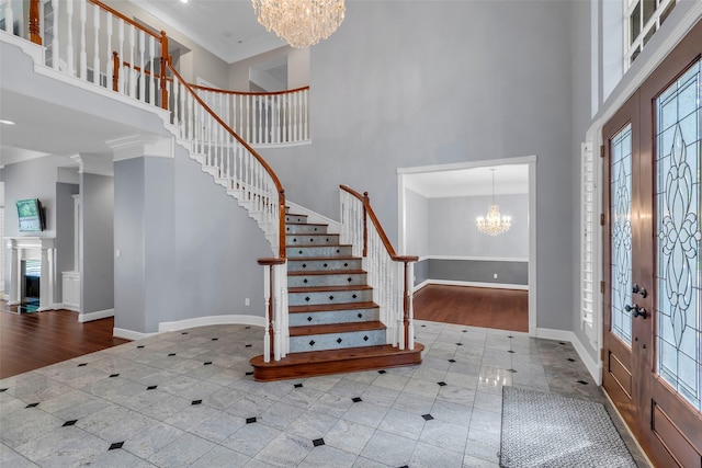 193 Grogans Point Rd, The Woodlands, TX 77380 - tiled foyer featuring a high ceiling, a chandelier, stairway, french doors, and inlaid floor details