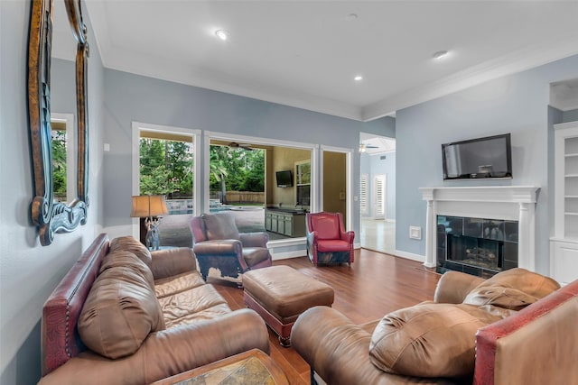 193 Grogans Point Rd, The Woodlands, TX 77380 - living room featuring wood finished floors, crown molding, a tiled fireplace, a ceiling fan, and recessed lighting