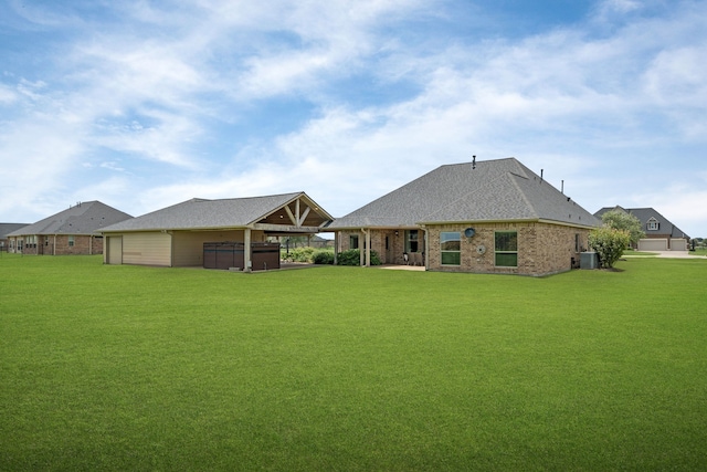 10527 Caddo Lake Dr, Needville, TX 77461 - rear view of house featuring a hot tub, a lawn, roof with shingles, and brick siding