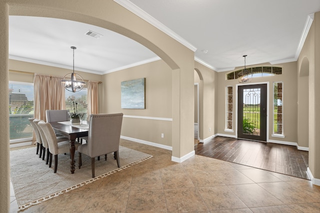10527 Caddo Lake Dr, Needville, TX 77461 - dining area with a chandelier, tile patterned floors, crown molding, and arched walkways