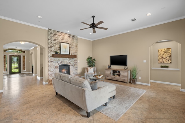 10527 Caddo Lake Dr, Needville, TX 77461 - living room with arched walkways, ceiling fan, ornamental molding, recessed lighting, and a brick fireplace