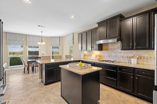 10527 Caddo Lake Dr, Needville, TX 77461 - kitchen featuring under cabinet range hood, tasteful backsplash, light tile patterned flooring, light stone counters, and recessed lighting