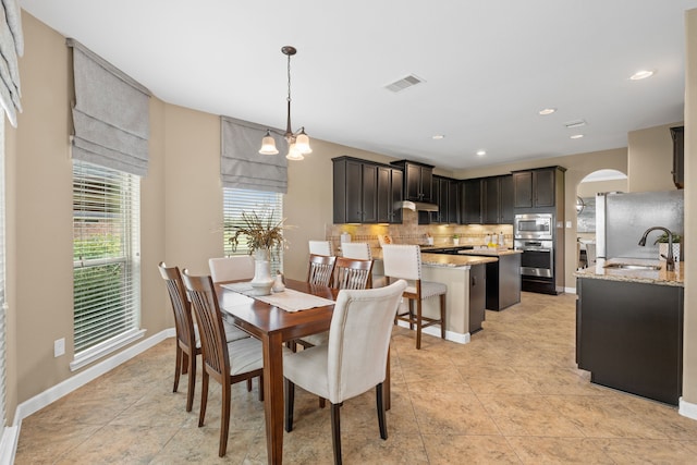 10527 Caddo Lake Dr, Needville, TX 77461 - dining area with arched walkways, light tile patterned flooring, recessed lighting, and a chandelier