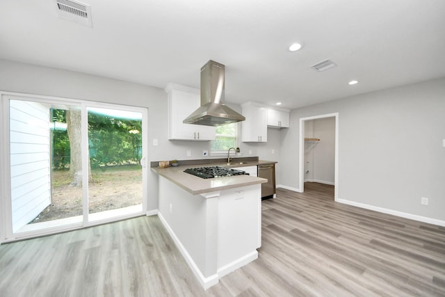 5634 Beldart St, Houston, TX 77033 - kitchen featuring wall chimney exhaust hood, dishwasher, light wood-style floors, white cabinetry, and recessed lighting