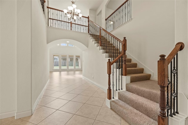 4403 Lodge Vine Ct, Sugar Land, TX 77479 - stairs featuring arched walkways, a chandelier, tile patterned floors, and a high ceiling