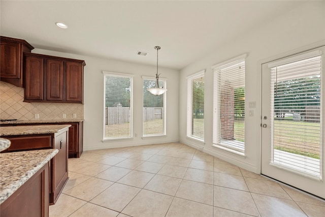 4403 Lodge Vine Ct, Sugar Land, TX 77479 - kitchen with tasteful backsplash, light stone counters, hanging light fixtures, light tile patterned flooring, and a chandelier