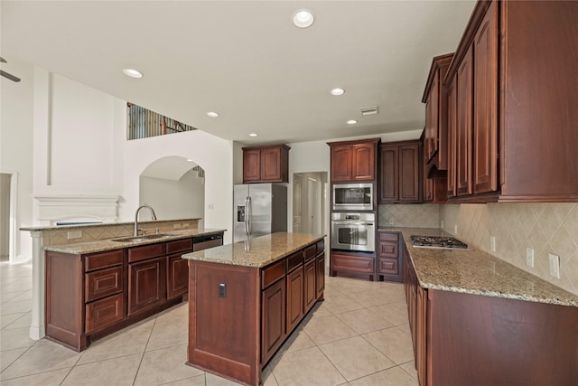 4403 Lodge Vine Ct, Sugar Land, TX 77479 - kitchen featuring appliances with stainless steel finishes, tasteful backsplash, light tile patterned flooring, a center island, and recessed lighting