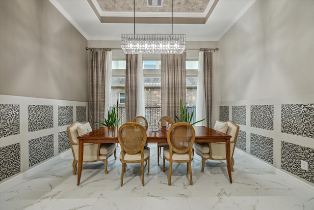 17310 Venado Dr, Cypress, TX 77433 - dining area with a raised ceiling, a chandelier, ornamental molding, marble finish floors, and wainscoting