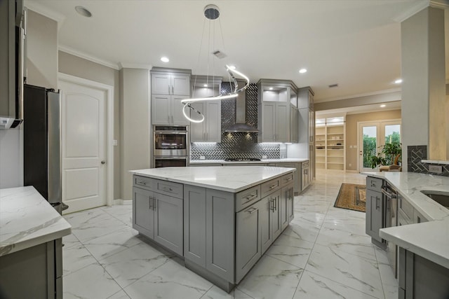 17310 Venado Dr, Cypress, TX 77433 - kitchen with gray cabinets, crown molding, appliances with stainless steel finishes, light marble finish flooring, and wall chimney exhaust hood