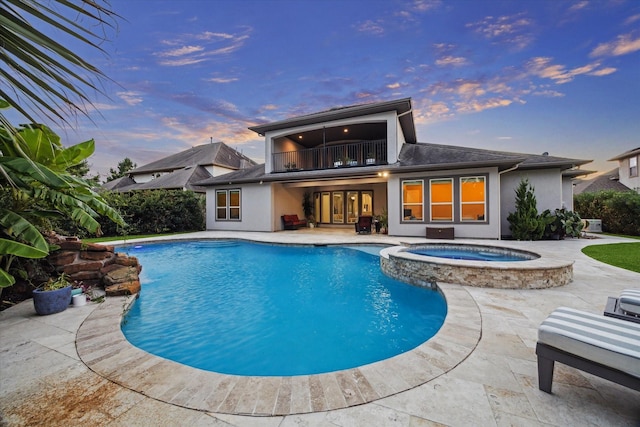 17310 Venado Dr, Cypress, TX 77433 - pool at dusk with a patio area, a pool with connected hot tub, and french doors