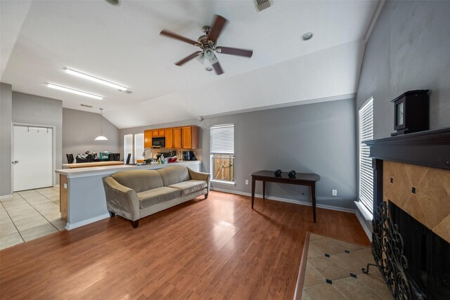 30927 N Head Dr, Spring, TX 77386 - living room with lofted ceiling, a fireplace, a ceiling fan, plenty of natural light, and light tile patterned floors