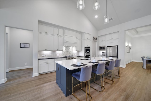 5350 Cherry Spring Dr, Spring, TX 77386 - kitchen with appliances with stainless steel finishes, high vaulted ceiling, decorative backsplash, white cabinets, and pendant lighting