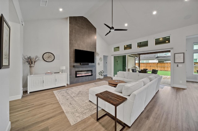 5350 Cherry Spring Dr, Spring, TX 77386 - living room featuring a ceiling fan, high vaulted ceiling, a tiled fireplace, wood finished floors, and recessed lighting