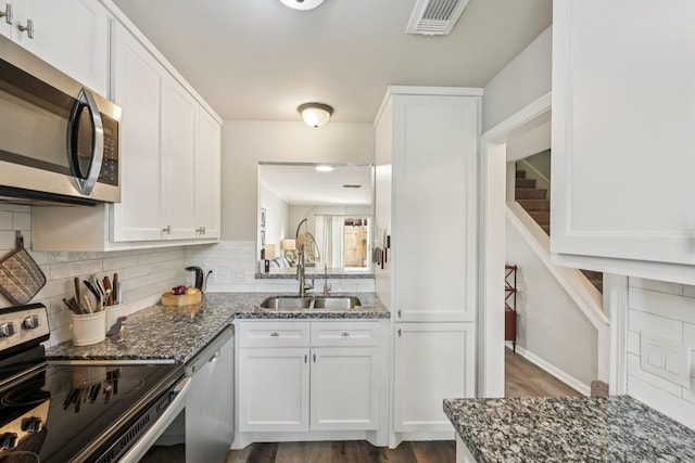 10676 Hazelhurst Dr, Houston, TX 77043 - kitchen with stainless steel appliances, backsplash, dark stone counters, and white cabinets