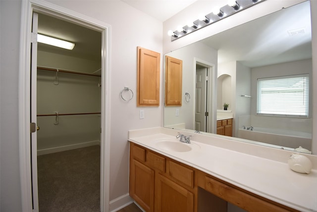 2611 Sandy Mist Ct, Katy, TX 77494 - bathroom with vanity, a walk in closet, and a bath