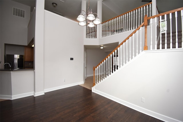 2611 Sandy Mist Ct, Katy, TX 77494 - stairs featuring a towering ceiling, a chandelier, and wood finished floors