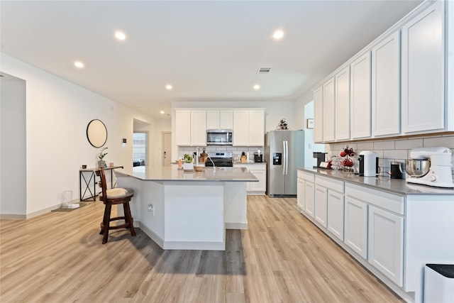7902 Sleek Flock Ln, Rosharon, TX 77583 - kitchen featuring appliances with stainless steel finishes, tasteful backsplash, light wood-type flooring, recessed lighting, and white cabinets
