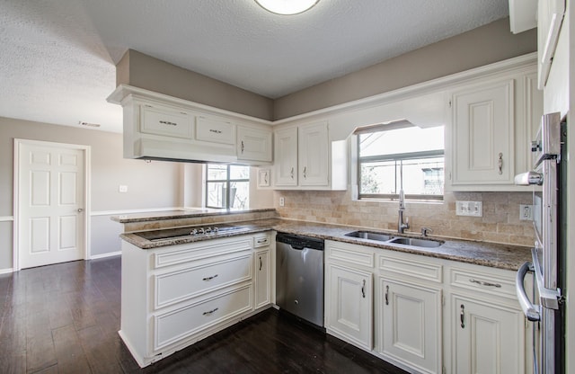 1511 Calveryman Ln, Katy, TX 77449 - kitchen with stainless steel dishwasher, black electric cooktop, a peninsula, decorative backsplash, and white cabinetry