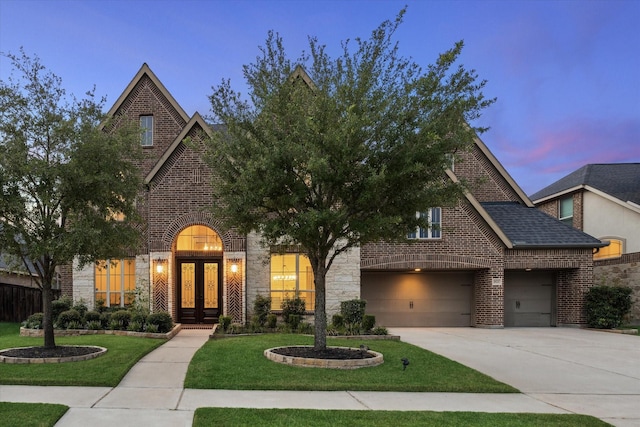 1923 Rice Mill Dr, Katy, TX 77493 - view of front of property with french doors, brick siding, concrete driveway, a lawn, and an attached garage