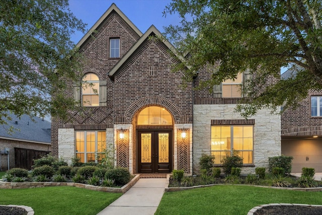 1923 Rice Mill Dr, Katy, TX 77493 - view of front of home with stone siding, brick siding, a front lawn, and french doors