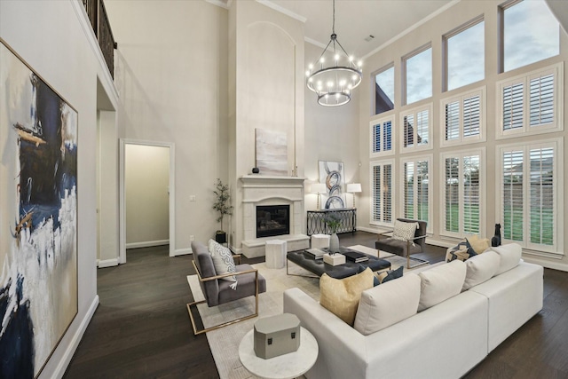 1923 Rice Mill Dr, Katy, TX 77493 - living room featuring a high ceiling, a chandelier, ornamental molding, dark wood-style flooring, and a glass covered fireplace
