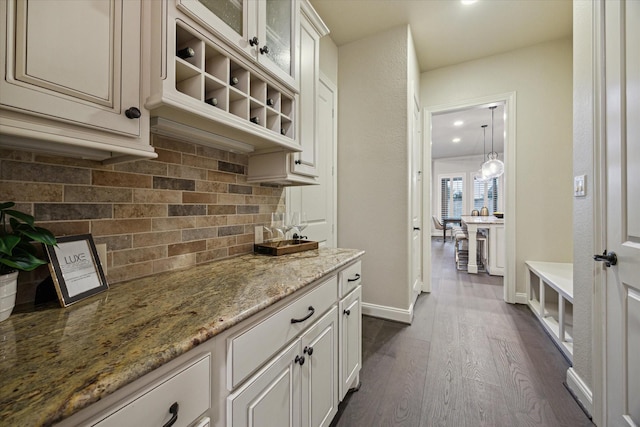 1923 Rice Mill Dr, Katy, TX 77493 - kitchen featuring backsplash, dark wood-type flooring, light stone countertops, glass insert cabinets, and recessed lighting