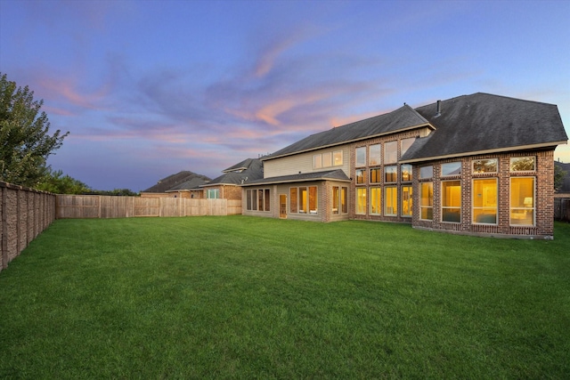 1923 Rice Mill Dr, Katy, TX 77493 - back of house at dusk with a fenced backyard and brick siding