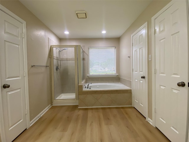 3210 Echo Mountain Dr, Houston, TX 77345 - bathroom featuring wood finished floors, a bath, a shower stall, and recessed lighting