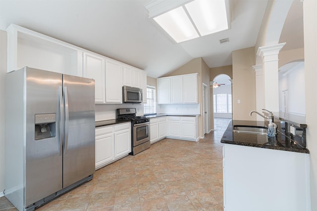 7314 Mountain Valley Dr, Houston, TX 77095 - kitchen featuring stainless steel appliances, arched walkways, white cabinets, ornate columns, and vaulted ceiling