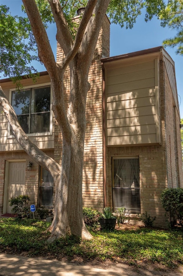 2110 Wilcrest Dr Unit 101, Houston, TX 77042 - view of side of home featuring brick siding and a chimney