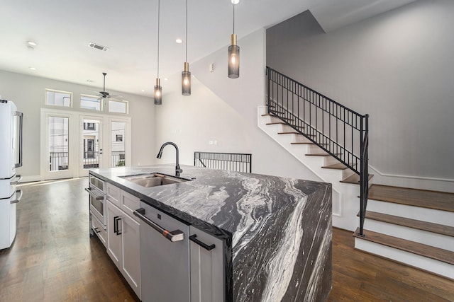 2221 Francis St, Houston, TX 77004 - kitchen featuring stainless steel appliances, a ceiling fan, dark wood-type flooring, a kitchen island with sink, and pendant lighting