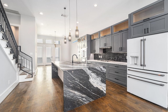 2221 Francis St, Houston, TX 77004 - kitchen with high end white refrigerator, gray cabinetry, dark wood finished floors, recessed lighting, and backsplash